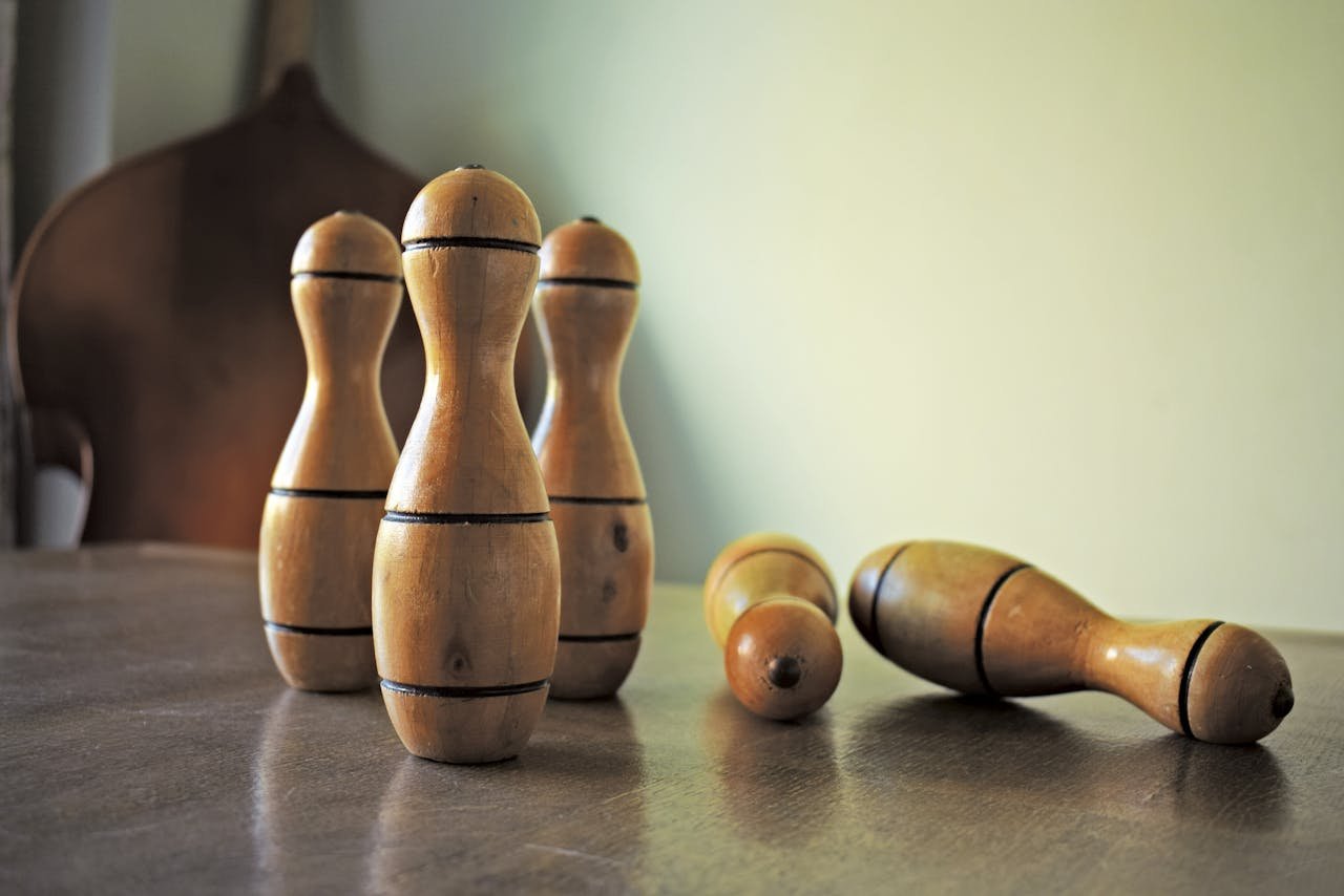 Close-up of wooden bowling pins arranged on a table indoors.